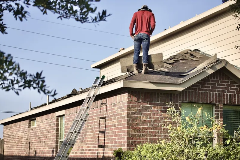 Professional roofer working on a residential roof in Mill Run Acres